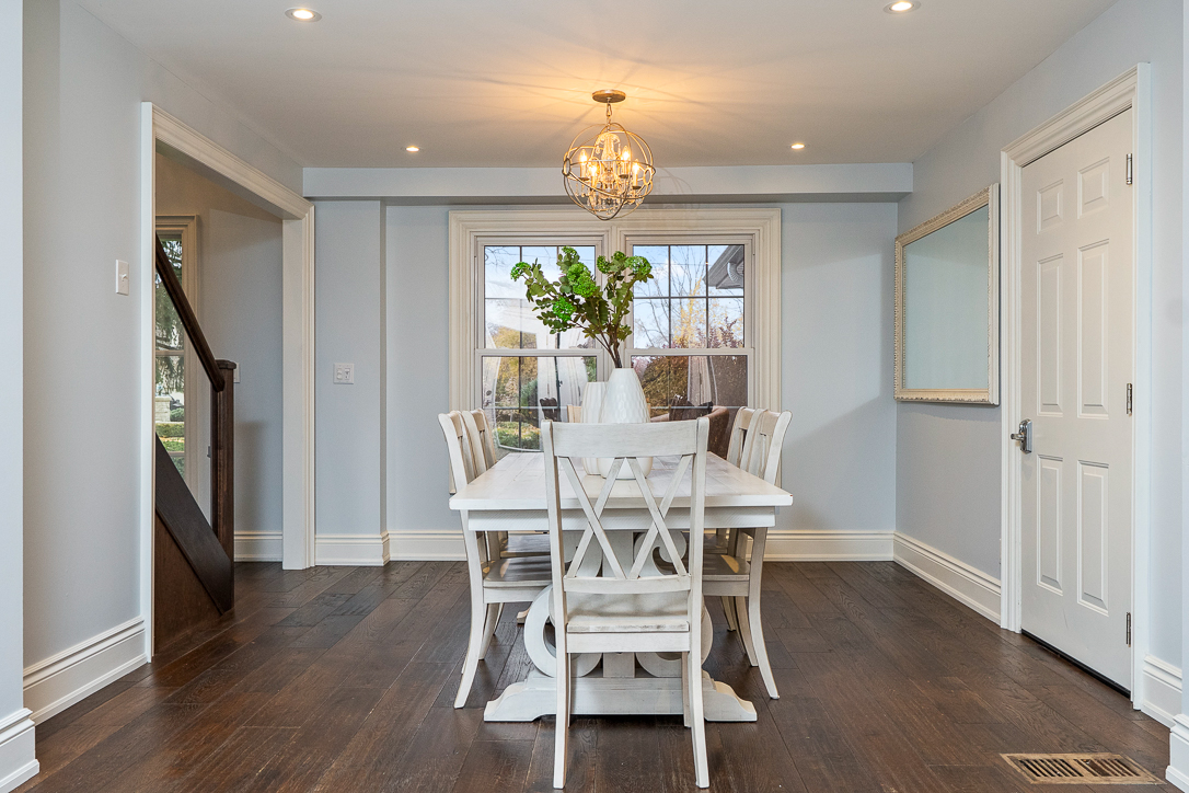 Bright dining room with a white table, chairs, and a chandelier
