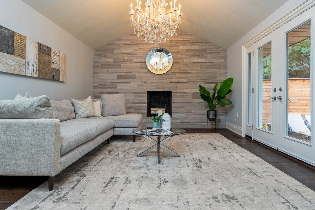Modern living room with a chandelier, fireplace, and large windows