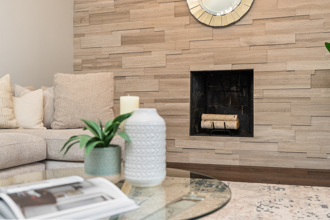 Cozy living room with a stone wall, fireplace, and decorative plants