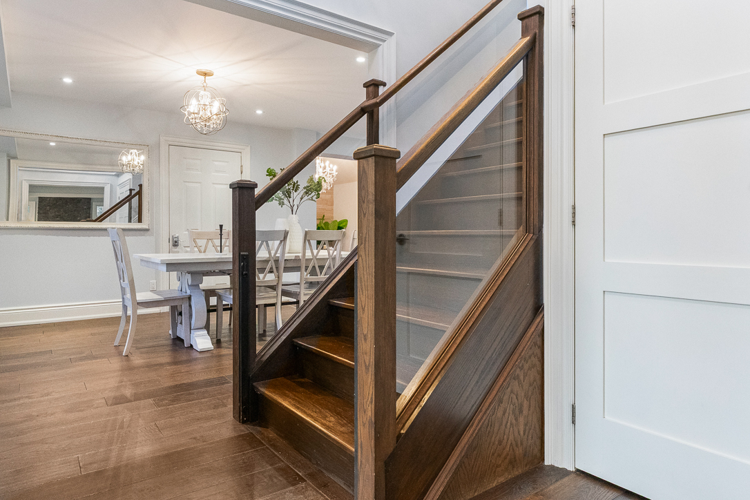 Wooden staircase leading to a bright dining area with elegant decor