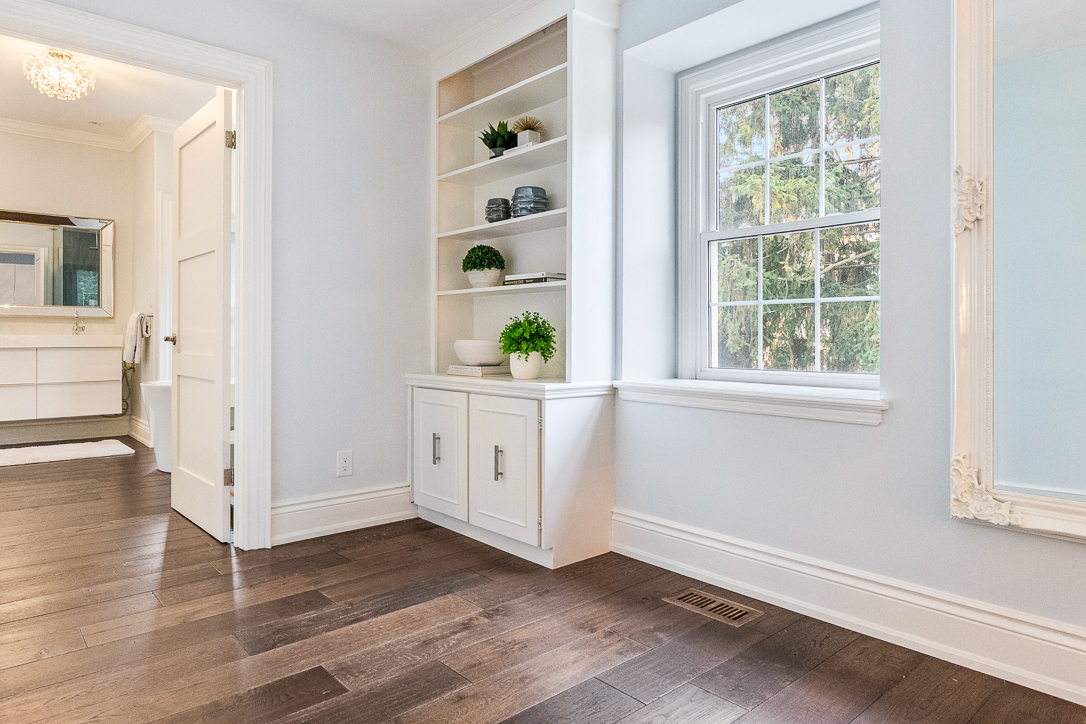 Bright room with hardwood floors, built-in shelves, and a large window
