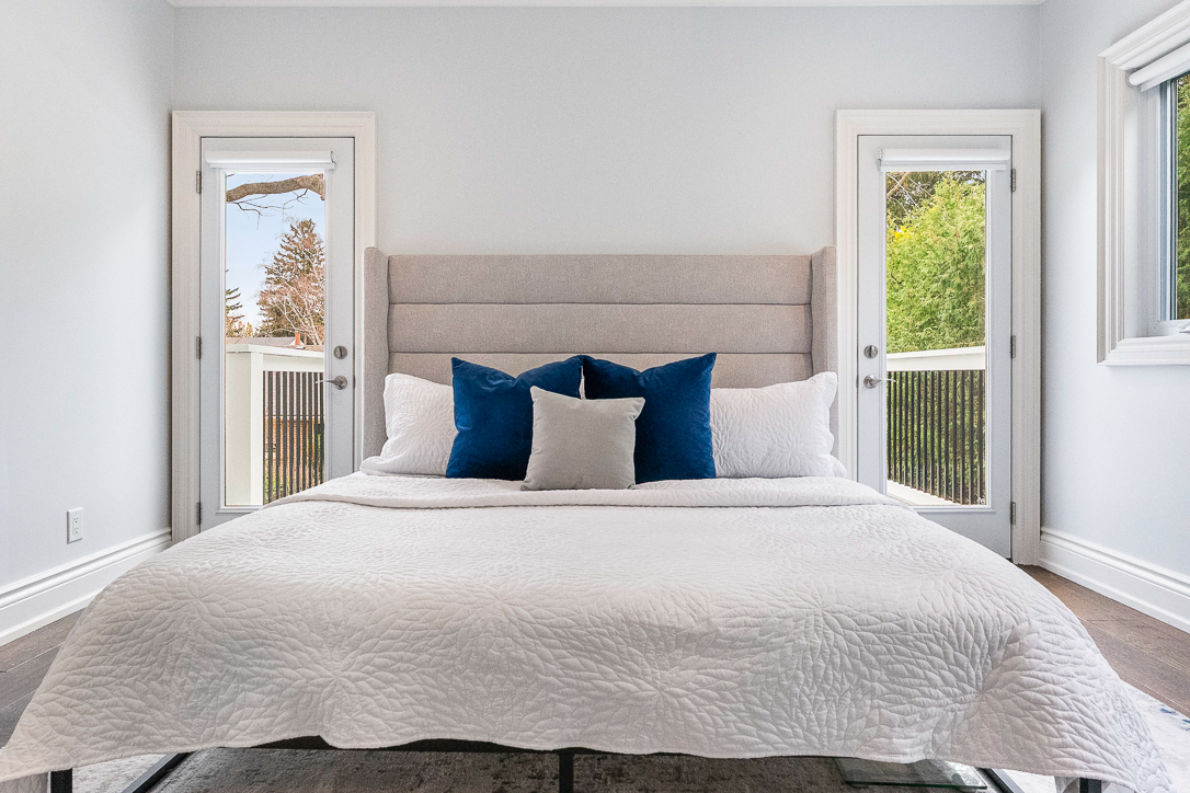 Modern bedroom with a light color scheme and blue accent pillows