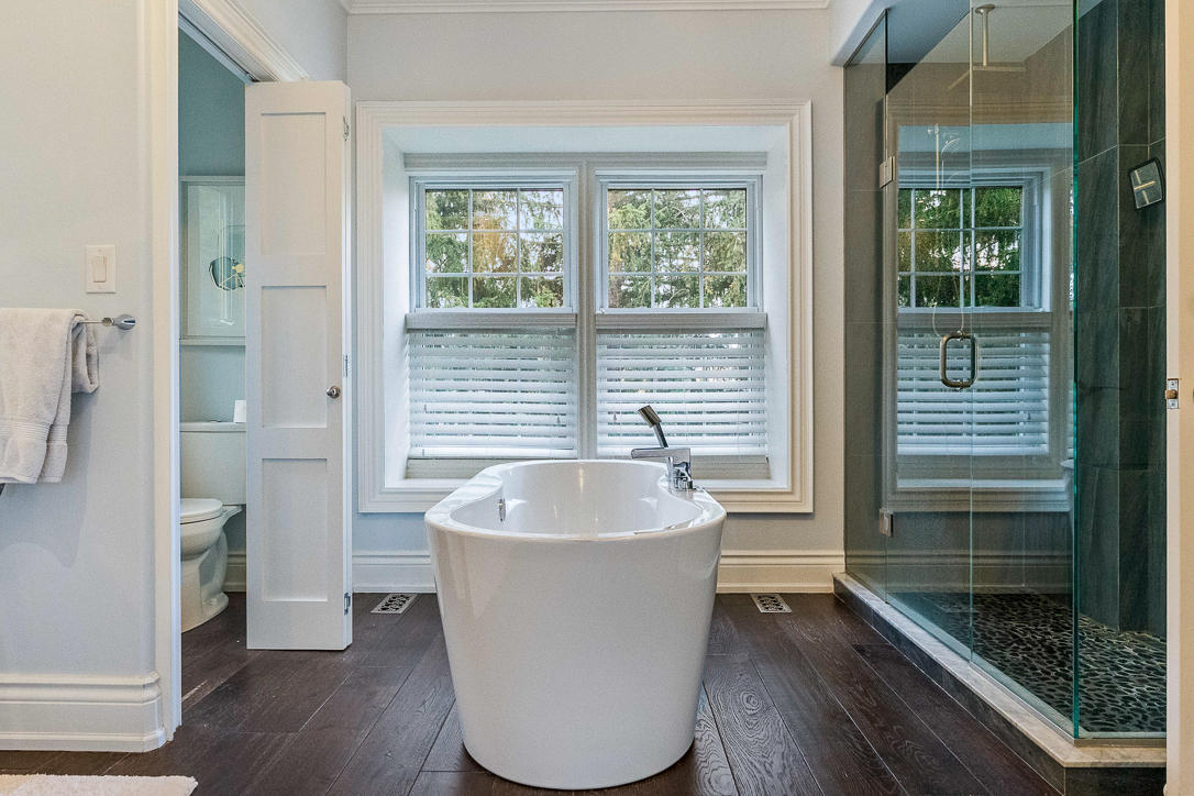 Modern bathroom featuring a freestanding tub and glass shower.