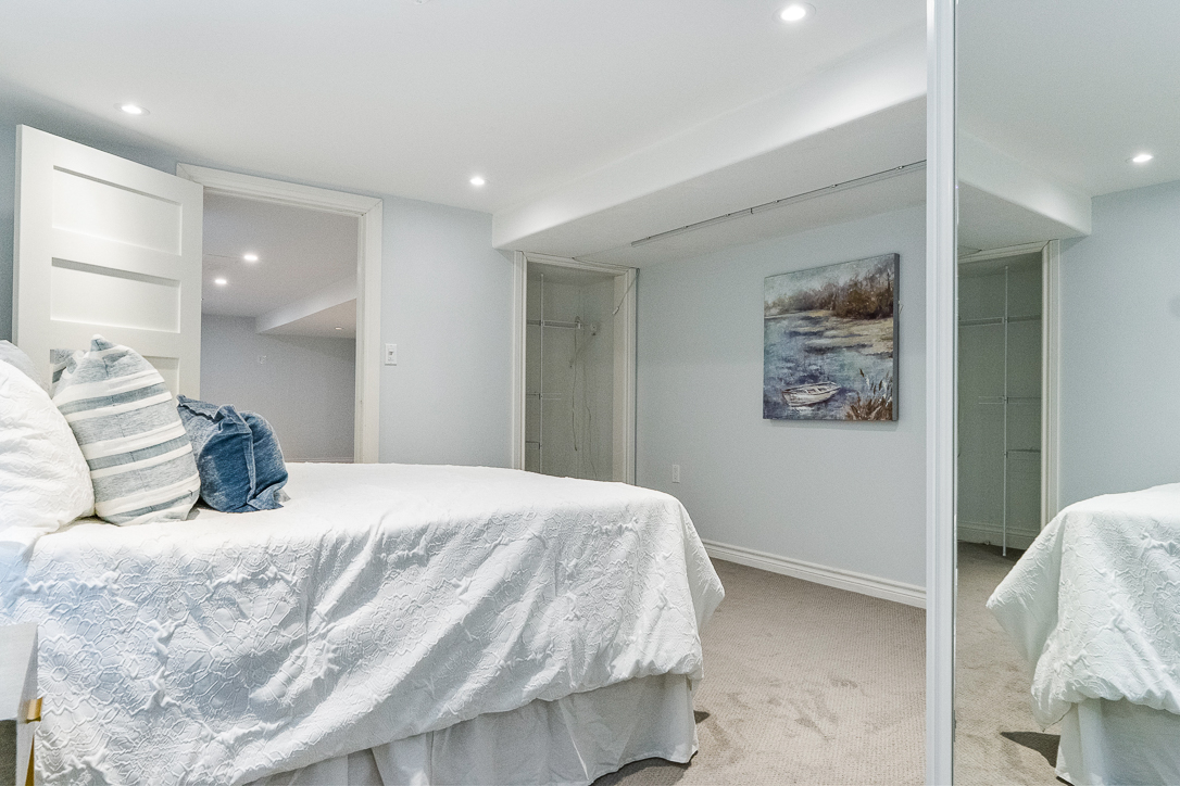 Cozy bedroom with a white bedspread and artwork on the wall