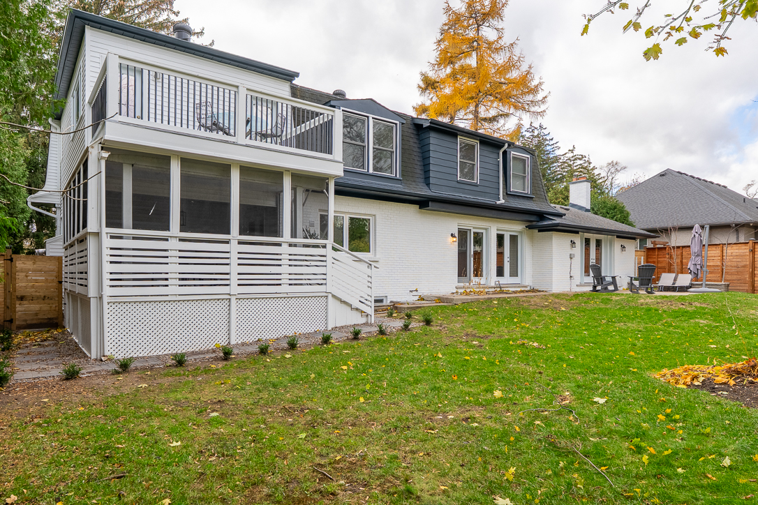 Modern white house with a spacious backyard and deck area