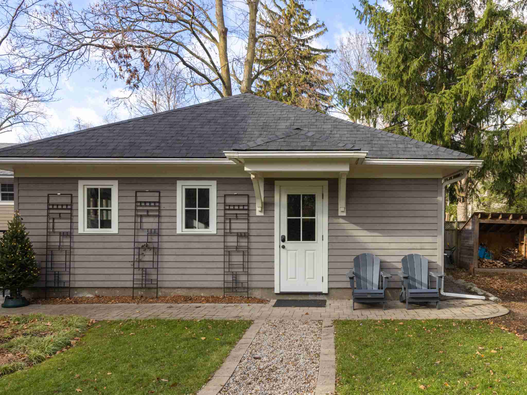 Side view of garage with door and muskoka chairs