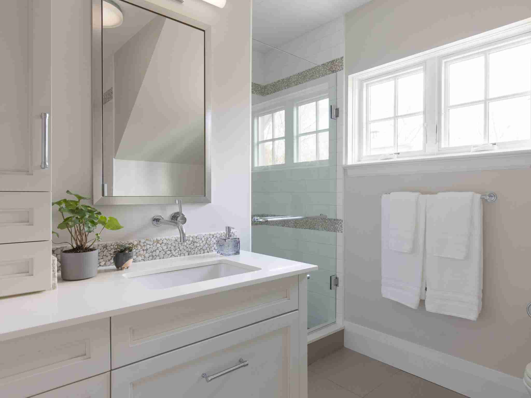 bedrooms bathroom with walk in shower and white cabinetry