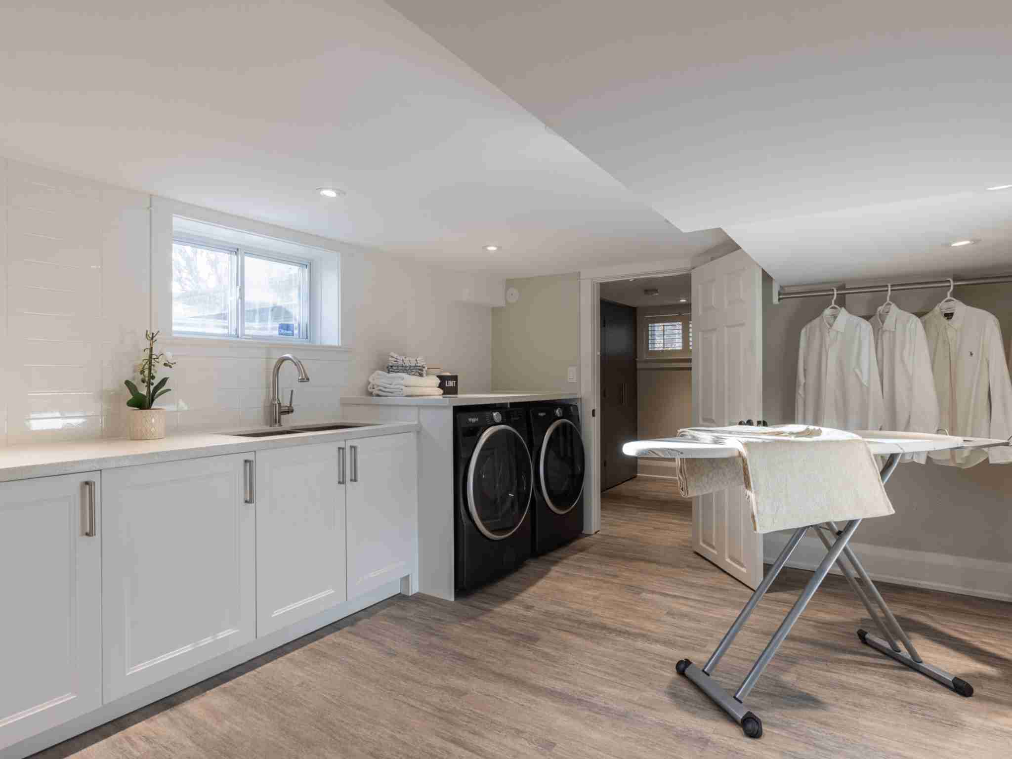 Laundry room with built in cabinets and sink