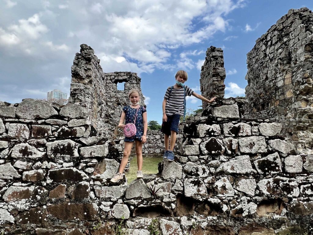 two children standing on a stone wall