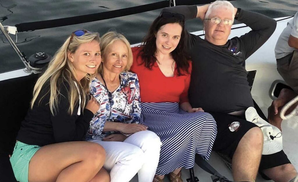 Four people are sitting on a boat. A man and three women.
