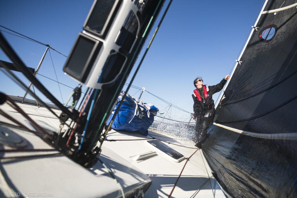 A sailor working on the bow of a boat. 