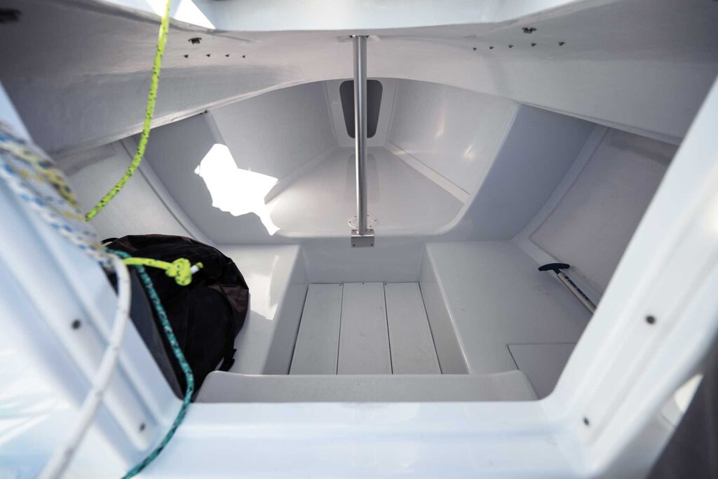 view of a berth below decks of the small daysailer. Show storage or possible overnight camping options.