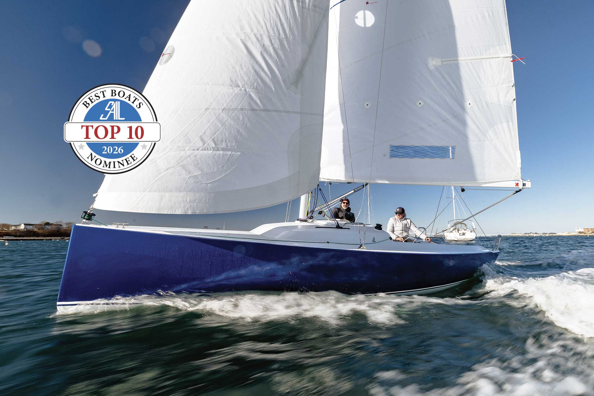00-LEAD-J_7.SamuelHodgesPhotography-02-copy-2048x J/7 undersail with a badge stating: Top 10 Best Boats 2026 Nominee