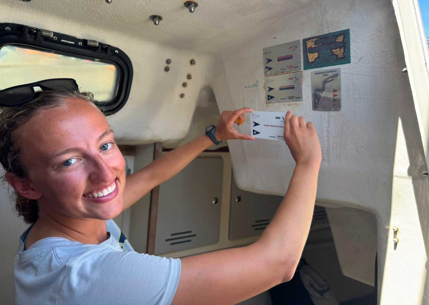 Nancy attaching this year’s Marion-Bermuda Race plaque to the Navy 44 Integrity’s bulkhead. Courtesy of Nancy Rhodes