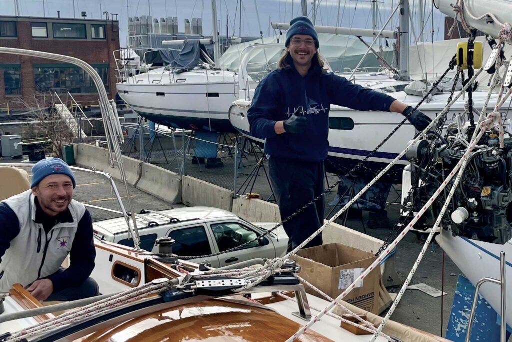 Two men smiling on a docked boat. 