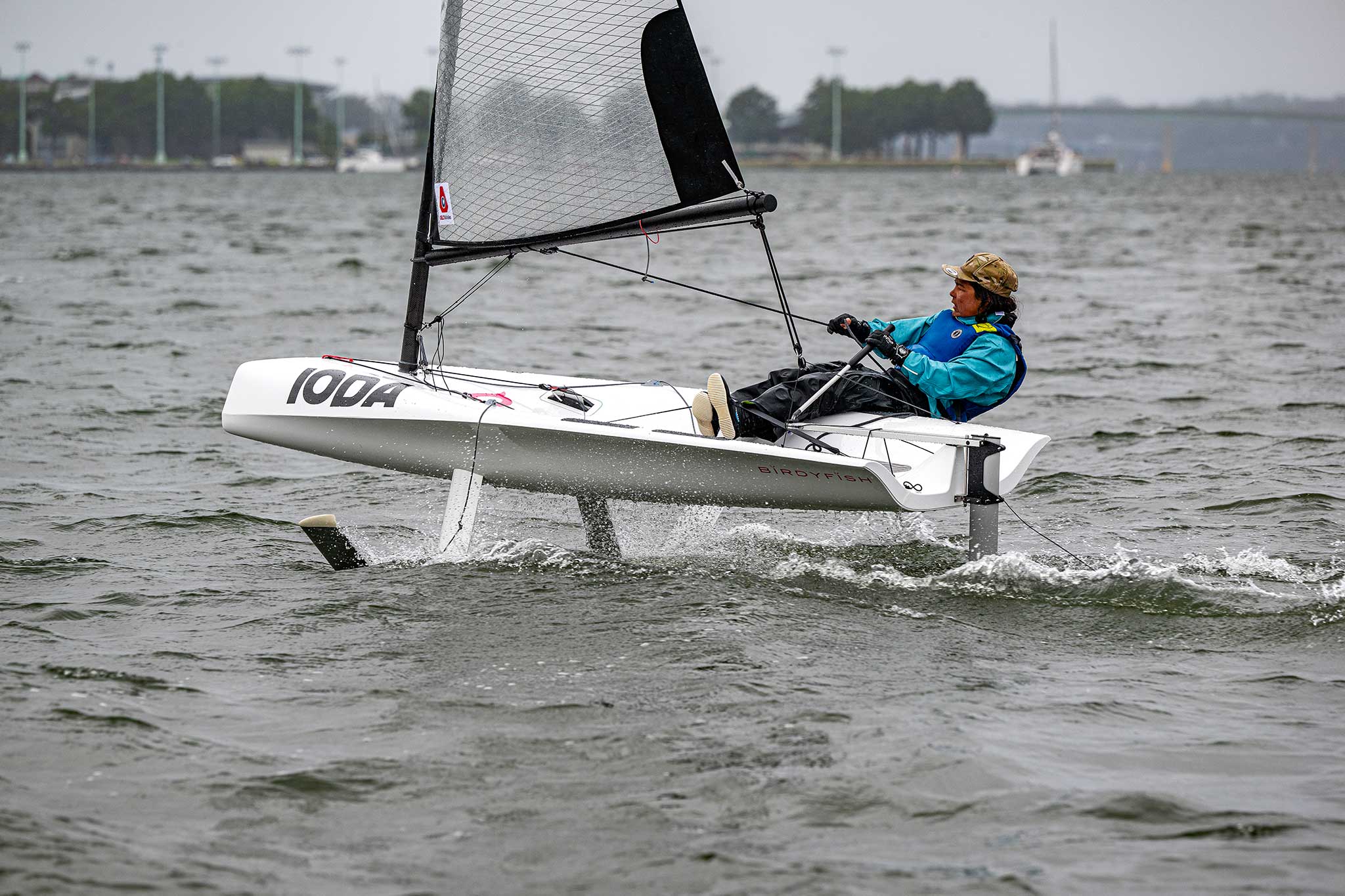 00-Ioda-0241 A smallboat with one passenger foiling above the water on a grey day