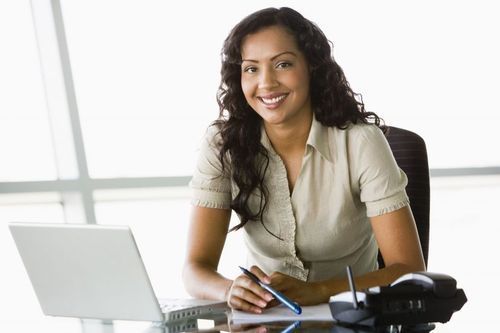 Section_image_in_office_with_laptop_smiling