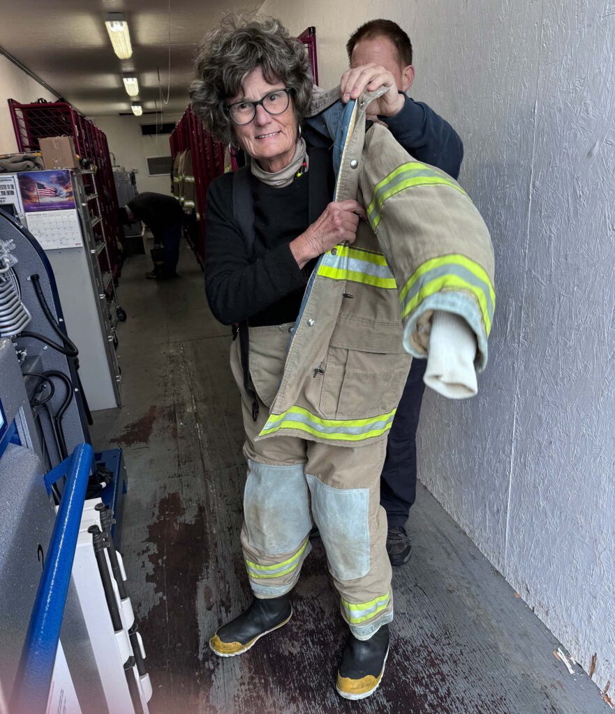 a woman holding a firefighter's jacket