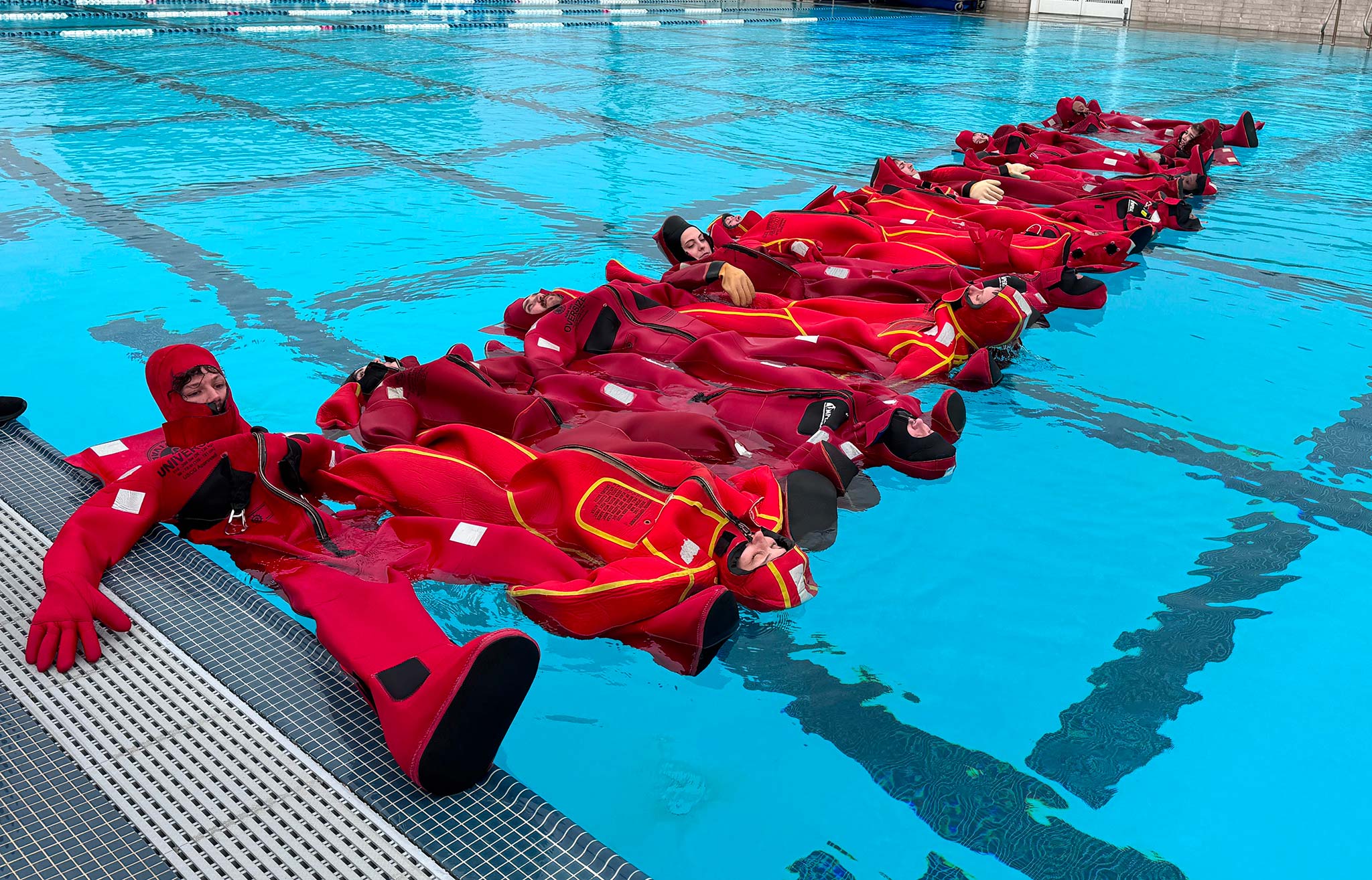 a group of people in red suits in a pool