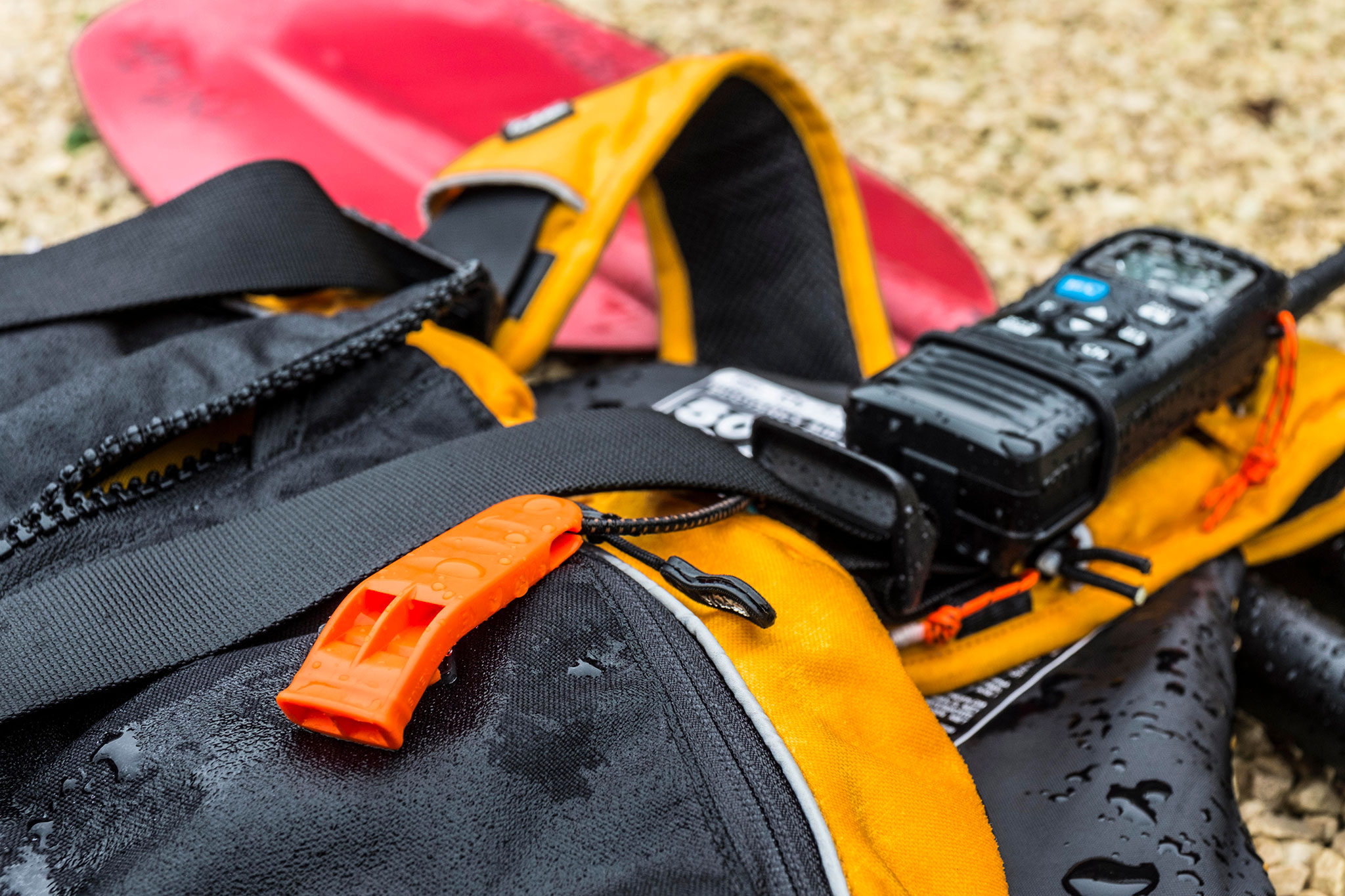 A  whistle is the bare minimum of what you should have on your lifejacket to attract attention. A handheld waterproof VHF radio is just one of many items you should seriously consider adding to your PFD. Photo: Alamy