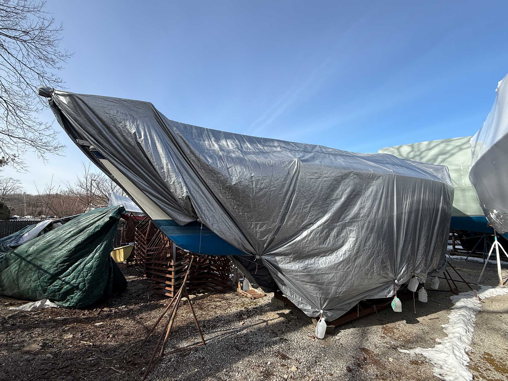 Water-filled jugs and rope tied to the cradle will keep the cover in place through the winter season.