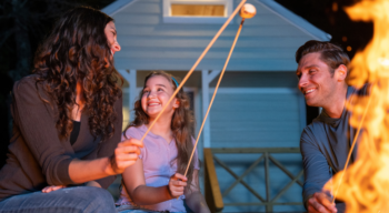 Family roasting marshmallows over a fire pit.