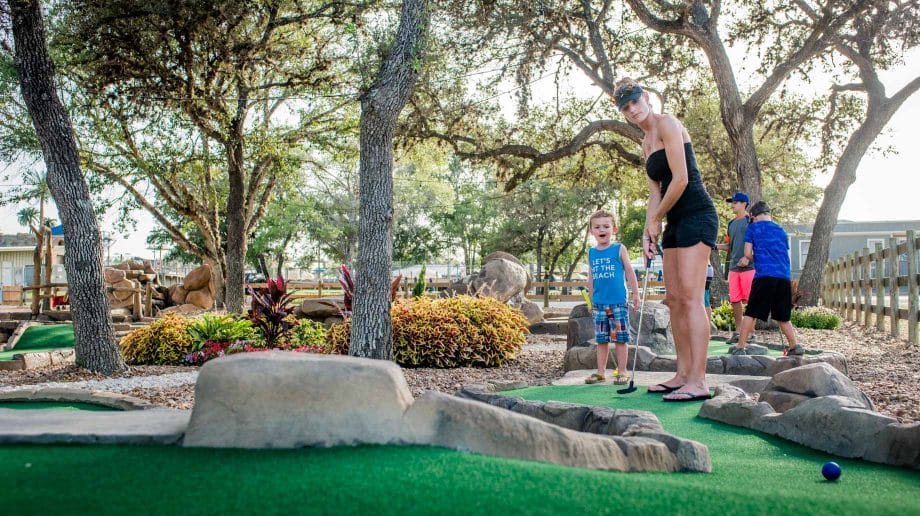 Woman and boy playing putt putt