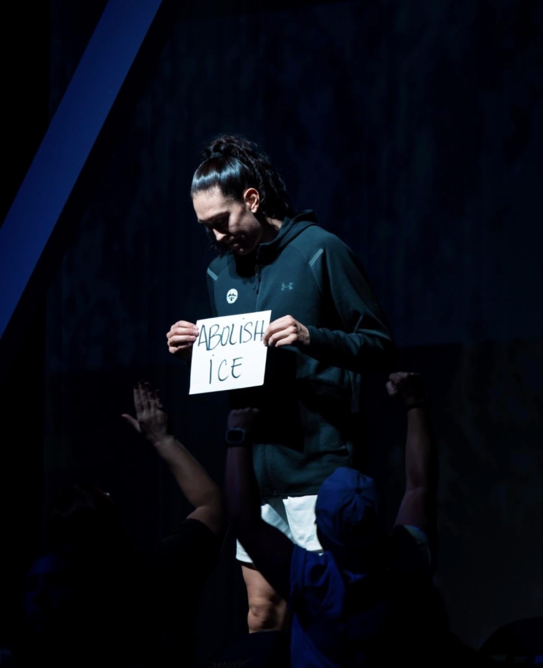 Breanna Stewart holding up an ICE protest placard