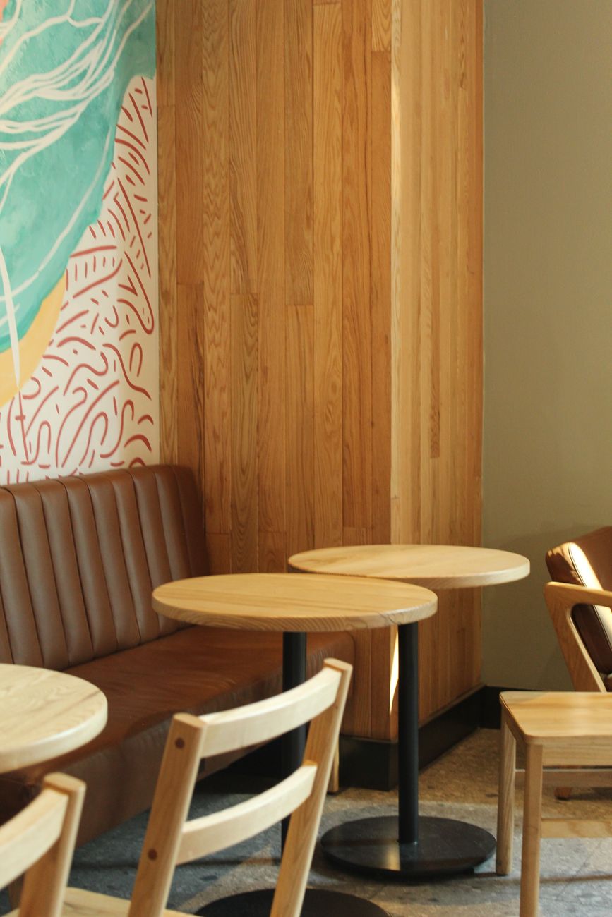 Cálido interior de un café con mesas y sillas de madera, perfecto para relajarse.