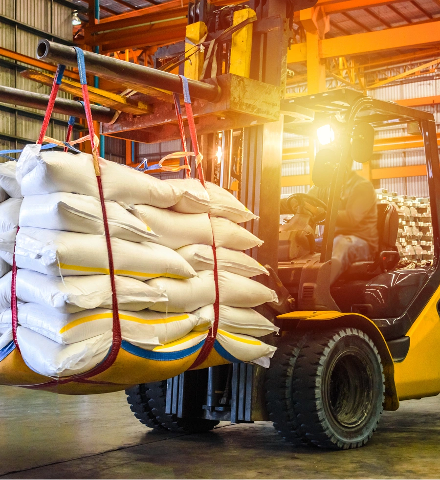 Forklift lifting bags of agricultural products in a warehouse setting