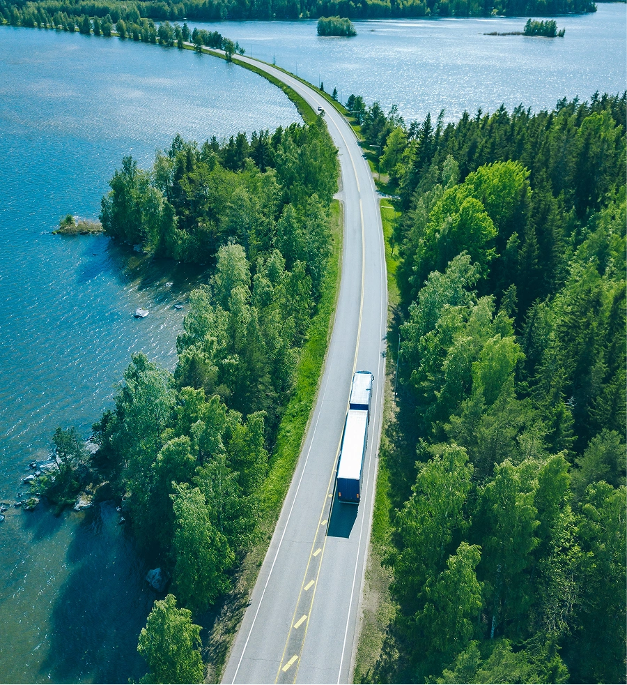 Truck driving over a road near water