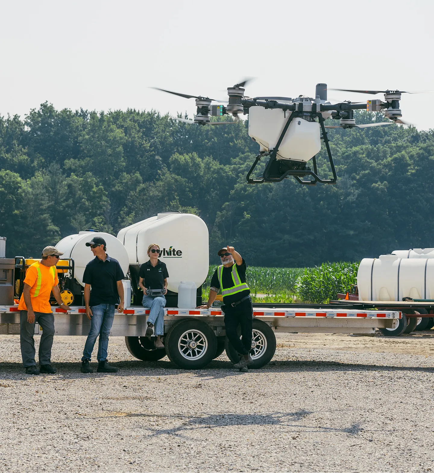 Agricultural drone flying over a Sylvite crew and trailer