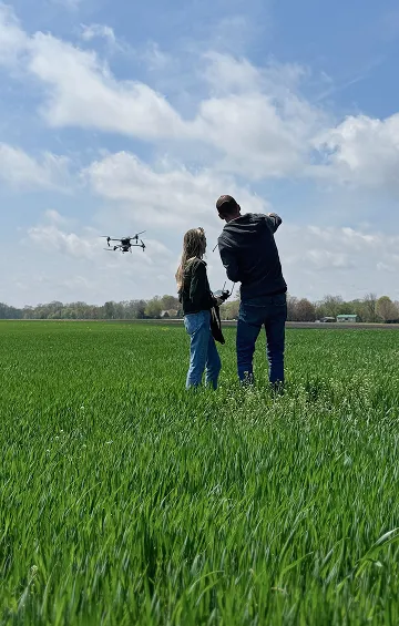 Sylvite agronomists flying a drone over a green field