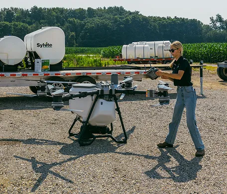 Sylvite team member preparing an agricultural drone beside a nurse trailer