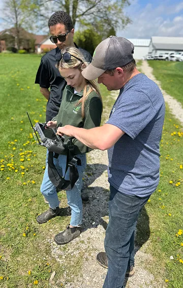 Sylvite team reviewing a drone controller in the field
