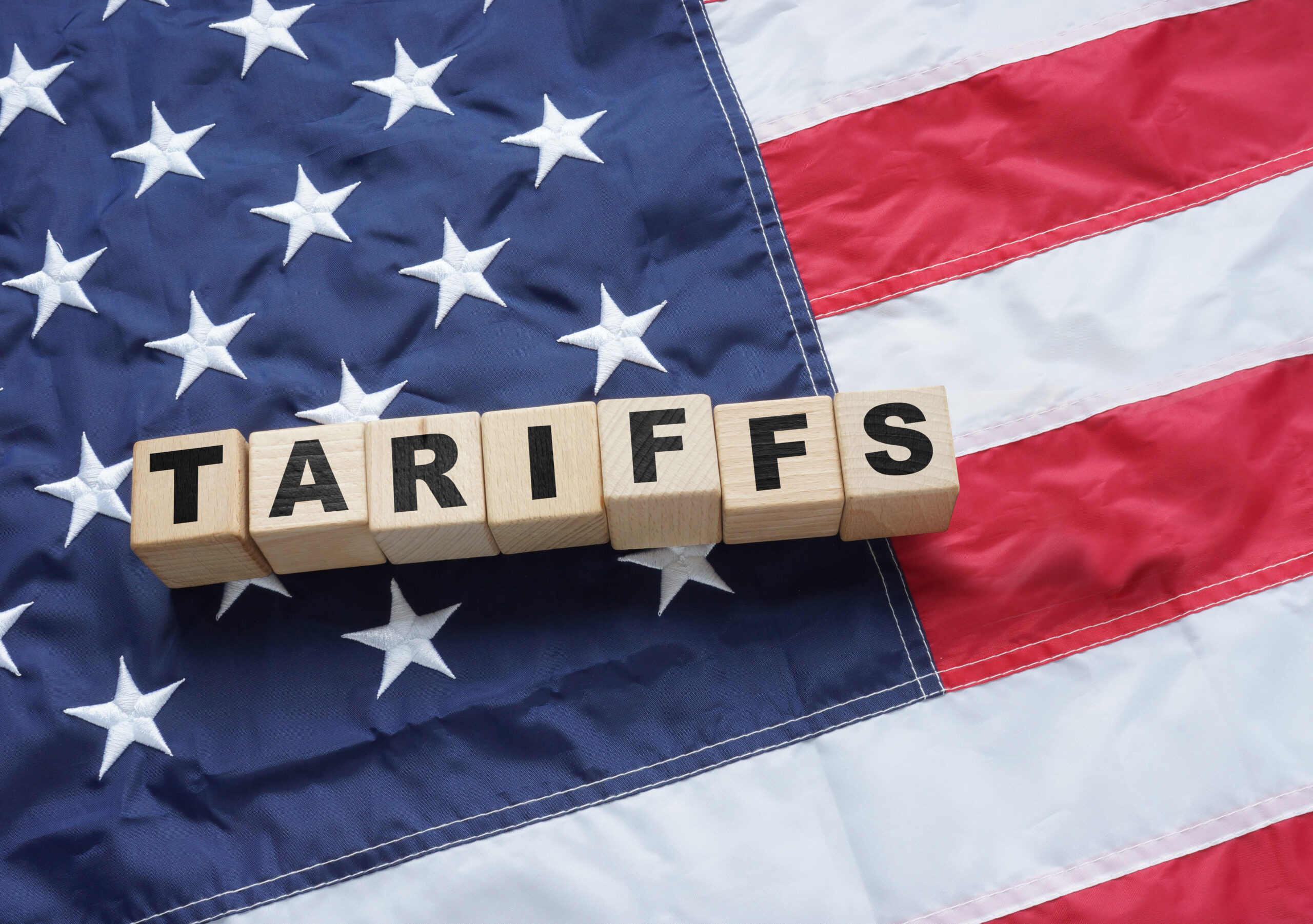 Import Trade Tariffs increase concept with United States of America Flag. Trade wars ANDRII - STOCK.ADOBE.COM PHOTO