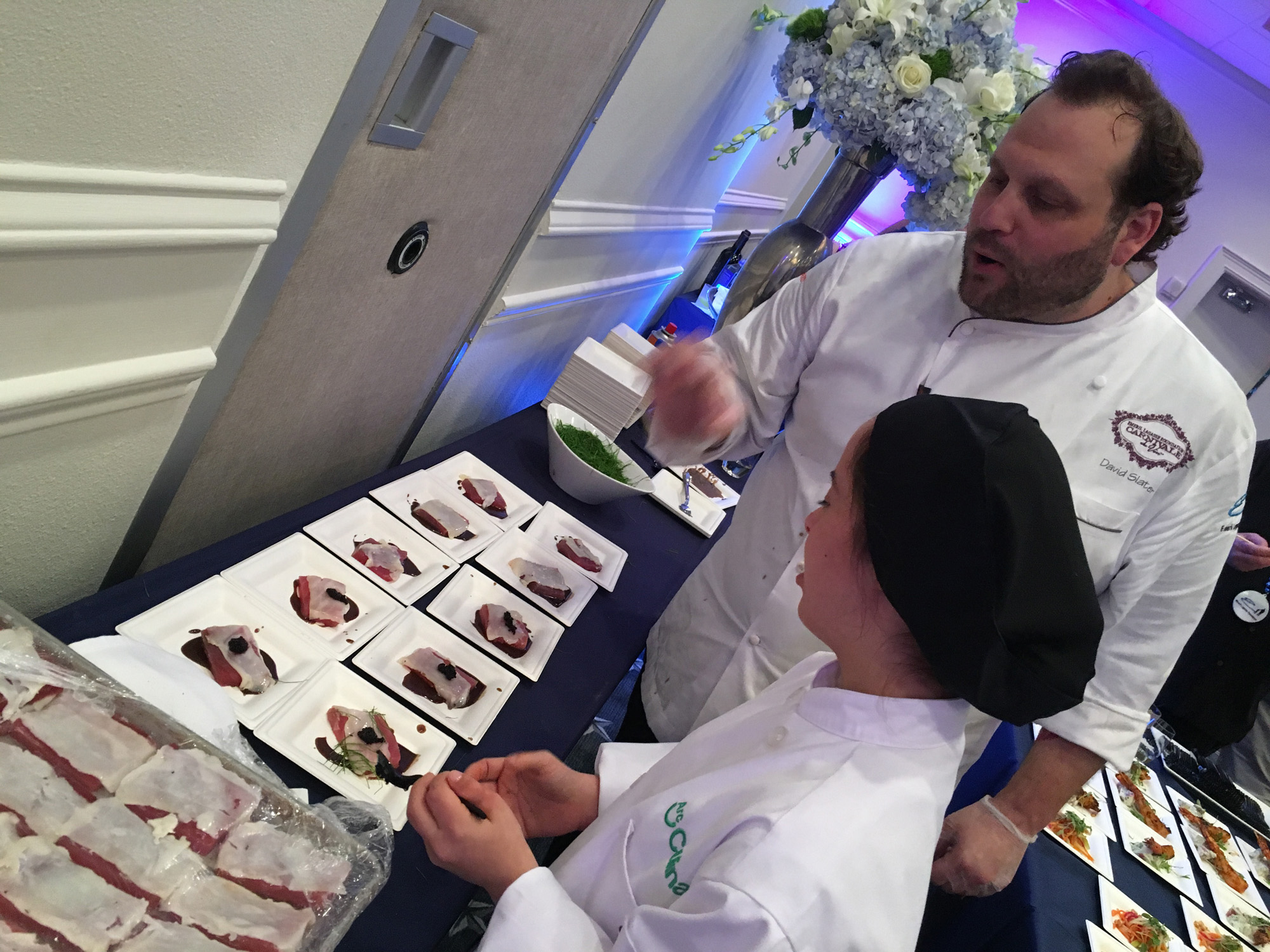 Chef David Slater and an Arc Broward culinary student prepare dishes for the Seafood Cook-off
