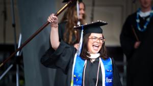 2024 Commencement - student celebrating with a cane