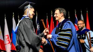 President Tepper presents a graduate with a cane