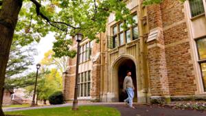 A student walks by the Christian Johnson (CJ) building on a sunny day.