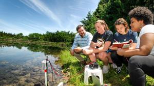 Professor Aaron Strong works with students at reservoir