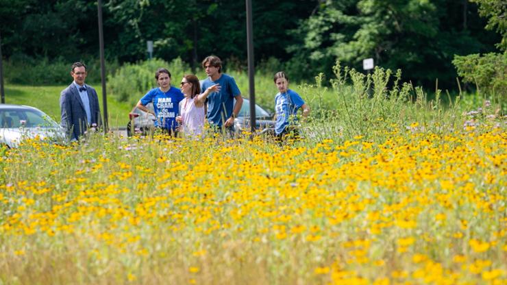 President Tepper, Sara Soika, and the Sustainability Coordinators tour the pollinator field.