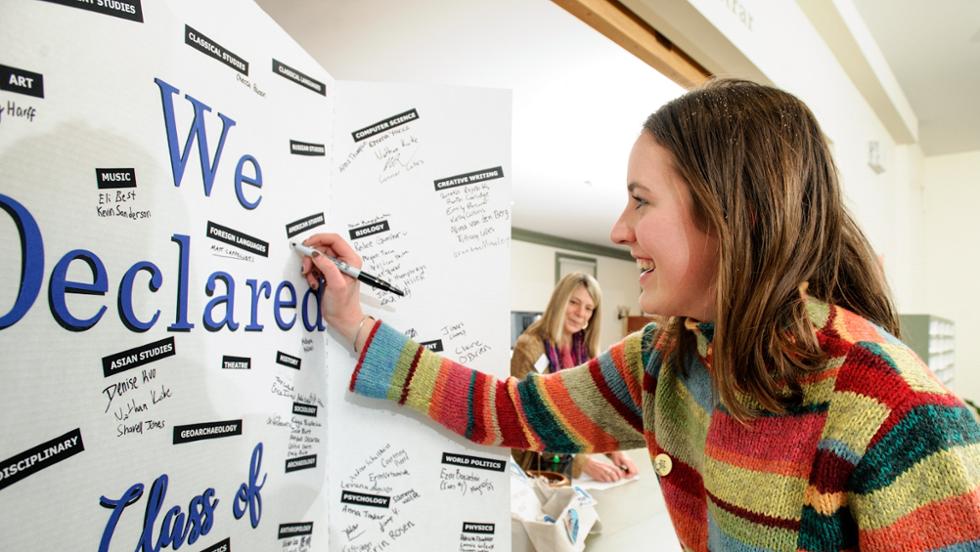 Kathryn Kearney '21 adds her major the declaration board in the registrar's office.
