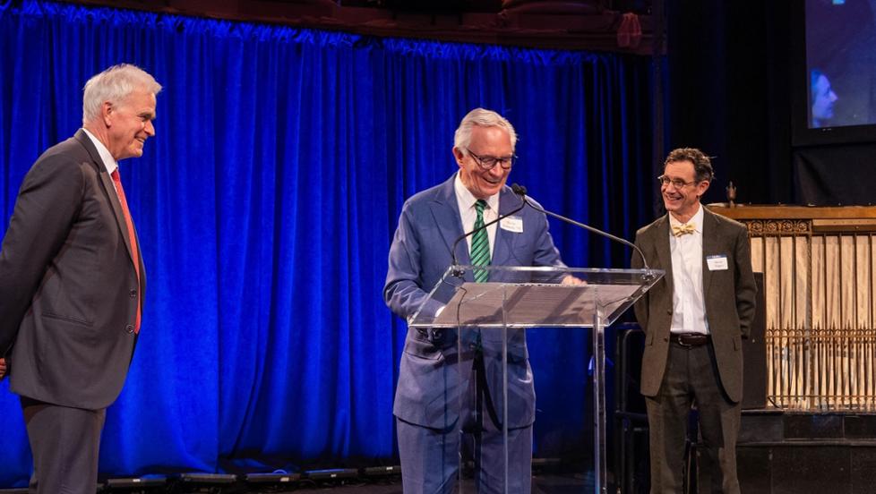 Trustee Kevin Kennedy ’70, center, presents trustee David Blood ’81, left, with an honorary degree.