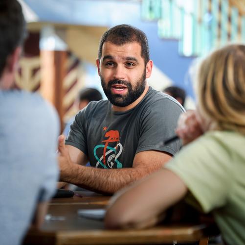 Assistant Professor of Economics Mo Alloush speaks with students