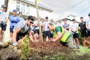Mike Mahanna, lead arborist with the Utica Urban Forest Revitalization Project, trains the Hamilton College Hockey team on how to plant trees.