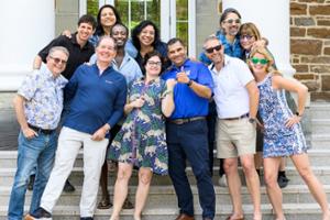 A posed photo of a group of adults on a staircase.