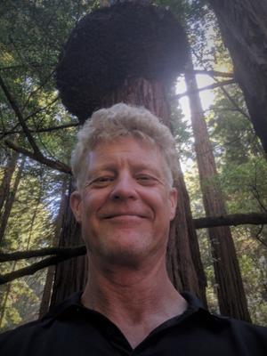 Head shot of Chris Luley in front of large tree.