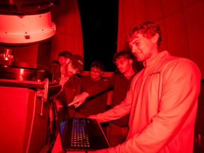 Associate Professor of Instruction for Physics Adam Lark and students in the Peters Observatory.