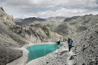 Backpackers above green lake